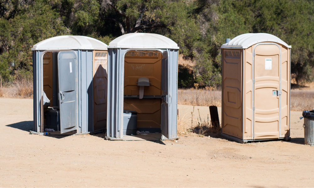 dirty outdated porta potties on a construction site